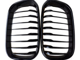 Two black kidney-shaped car grilles with horizontal slats are positioned side by side against a white background, emphasizing their glossy finish and symmetrical design.