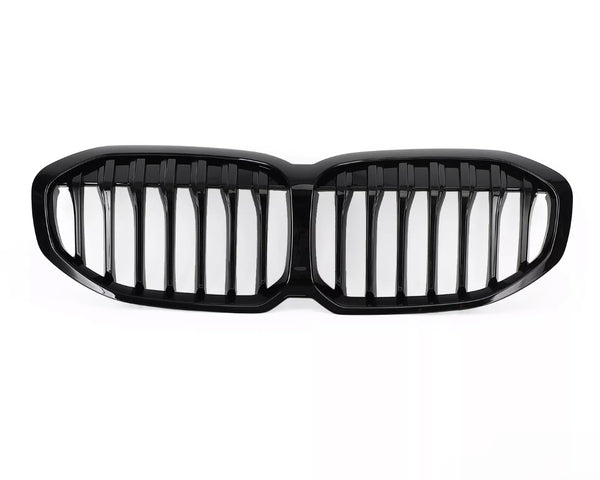 A glossy black car grille, featuring vertical slats, lies on a plain white background, designed to fit the front of a vehicle, enhancing its appearance and functionality.