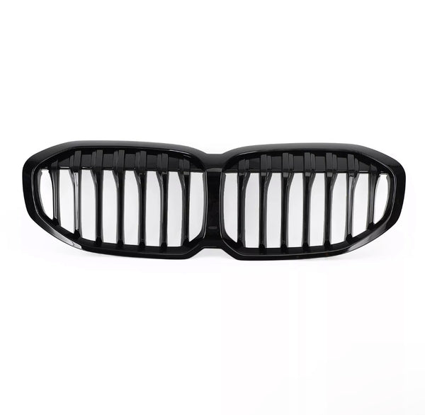 A glossy black car grille, featuring vertical slats, lies on a plain white background, designed to fit the front of a vehicle, enhancing its appearance and functionality.
