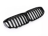 A glossy black car grille, featuring vertical slats, rests on a white background, designed for vehicle front-end styling and air flow.