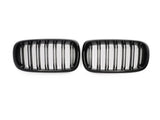 Two black car grilles, each with vertical slats, are positioned side by side against a plain white background.