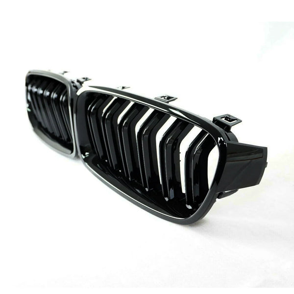 A glossy black car grille with vertical slats rests on a white background, showcasing sleek, modern automotive design.