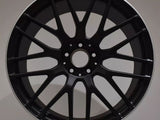 A black alloy wheel with multiple spokes, labeled 