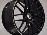A black alloy wheel displayed upright. Its multi-spoke design features 