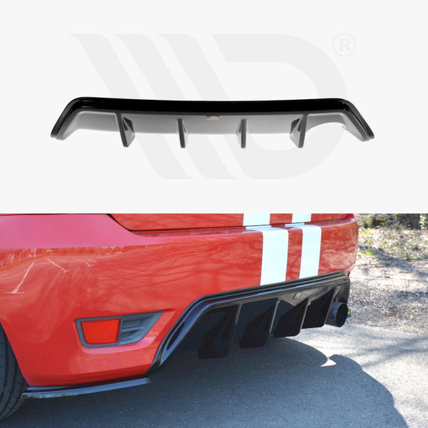 A black car diffuser is displayed. In use, it attaches to the rear of a red car with white racing stripes. The car is parked on a sunny street.