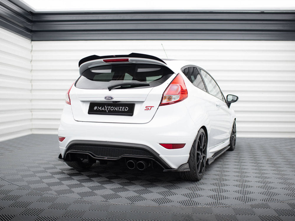 A white Ford hatchback with "ST" badge is parked on a checkered floor in an enclosed, light-colored garage. License plate reading "#Maxtonized."