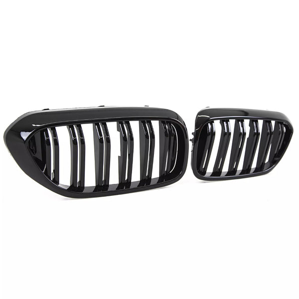 Two glossy black car grilles, featuring vertical slats, are positioned against a plain white background, highlighting their sleek and modern design.