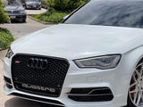 A white Audi car with a prominent black grille is parked on a concrete surface. The word 