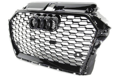A black car grille showcases interlocking silver hexagonal patterns with a prominent set of four interlinked rings in the center, symbolizing a well-known automotive brand.