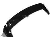 A glossy black car spoiler is shown on a plain white background, highlighting its aerodynamic curve and smooth surface.
