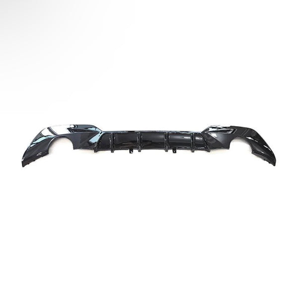 A black car bumper is laid against a plain white background, showcasing its aerodynamic design with curved edges and integrated vent-like features.