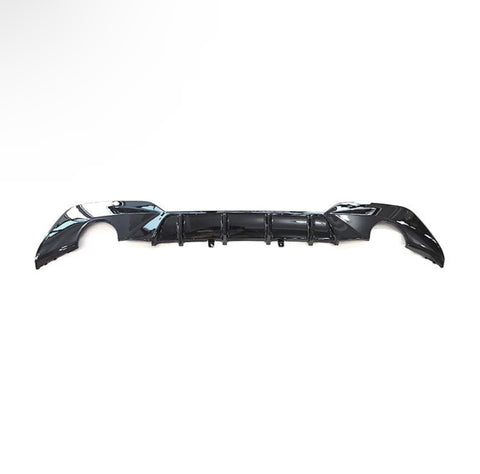 A black car bumper is laid against a plain white background, showcasing its aerodynamic design with curved edges and integrated vent-like features.