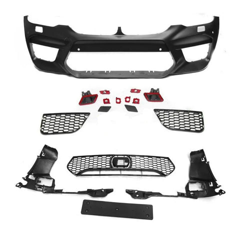Assorted black car bumper parts, including a large bumper frame and multiple grilles, lay arranged on a white surface, showcasing components typically used in vehicle front-end assembly.