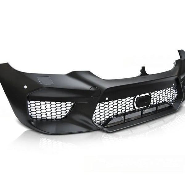 A black car front bumper with a honeycomb grille sits on a white reflective surface, displaying a sleek and aerodynamic design with empty light spaces.