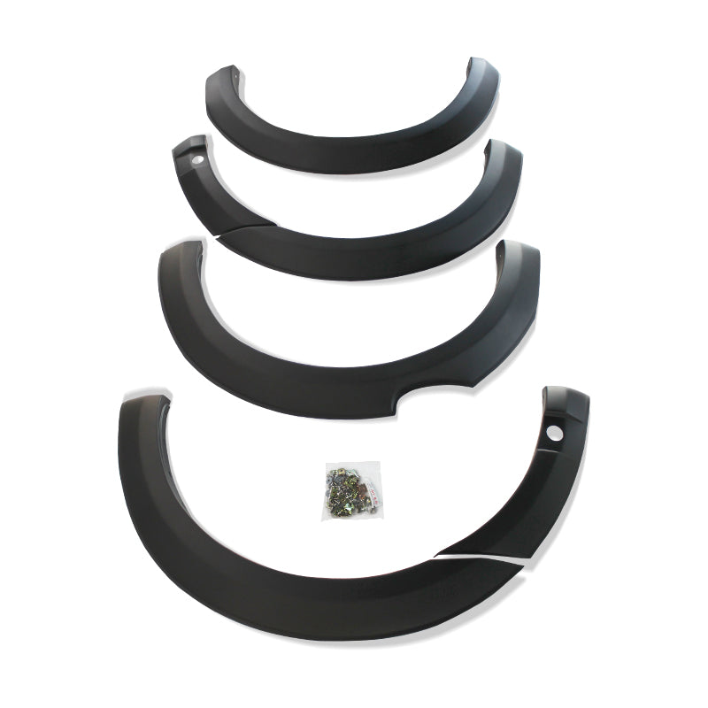 Four black car fender flares are arranged in descending size order. A small plastic bag containing screws lies in the center on a white background.