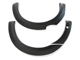 Curved, black plastic automotive fender flares are displayed against a plain white background. There are two pieces, showcasing their smooth, rounded shape and sturdy construction.