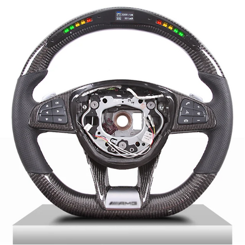 A carbon-fiber steering wheel features multifunction buttons on the sides and a digital display at the top. The center is missing, revealing internal mechanisms. Display text: "3000 RPM, 120 km/h."