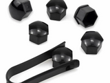 Black lug nut covers and a removal tool are arranged on a plain background. The covers are hexagonal, reflecting light, while the tool is elongated with gripping ends for ease of use.