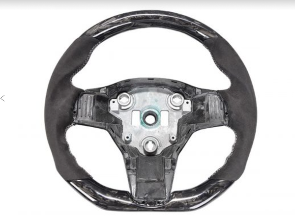 A car steering wheel, lacking its central cover, displays its bare metal core and attachment points, surrounded by black material, set against a plain white background.