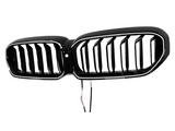 A shiny black car grille with vertical slats is suspended against a plain white background. Two wires dangle below, indicating electrical connectivity for installation.