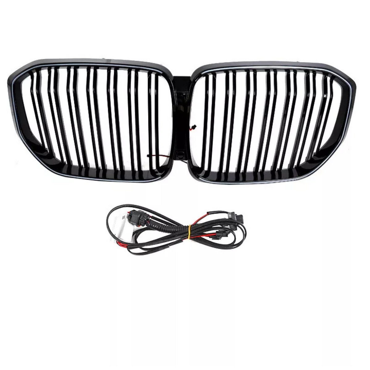 A black car grille with vertical slats is positioned above a coiled set of black electrical cables, both set against a plain white background.