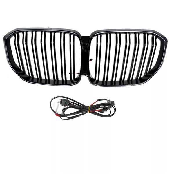 A black car grille with vertical slats is positioned above a coiled set of black electrical cables, both set against a plain white background.
