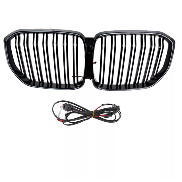 A black car grille with vertical slats is positioned above a coiled set of black electrical cables, both set against a plain white background.