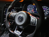 A car steering wheel with a carbon fiber texture is positioned at the center, displaying a Volkswagen logo. Surrounding digital dashboard panels show speedometer and vehicle information in a dimly lit car interior.