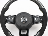 Steering wheel with carbon fiber accents and VW logo, featuring multi-function buttons for control. It rests against a plain white background.