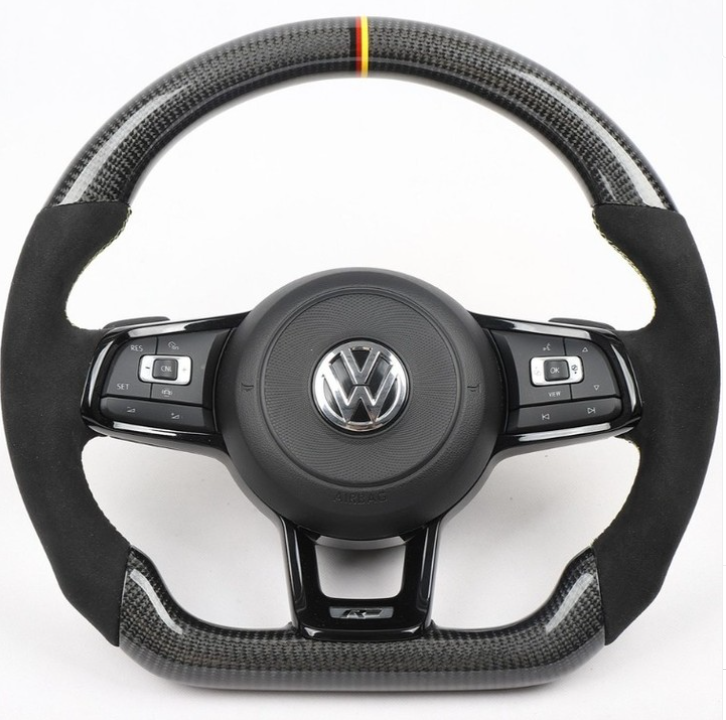 Steering wheel with carbon fiber accents and VW logo, featuring multi-function buttons for control. It rests against a plain white background.