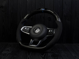 A Volkswagen steering wheel, featuring buttons and a sleek design, rests against a dark, textured wooden backdrop.