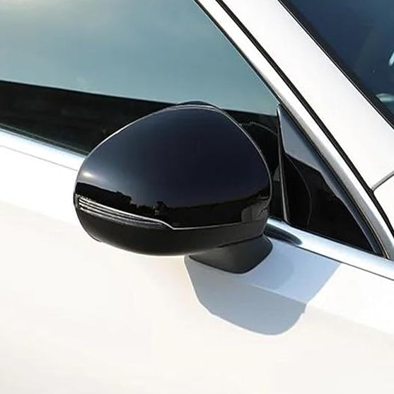 A black side mirror is attached to a white car, reflecting light in a sunny outdoor setting. The vehicle's window and frame are partially visible.