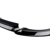A black car bumper lip sits on a white background. It features a sleek, curved design with an aerodynamic structure, designed to fit under a vehicle’s front bumper.