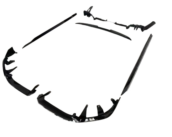 Black car body kit components are arranged on a plain white background. The pieces include bumpers and side skirts, designed to enhance vehicle aerodynamics and appearance.