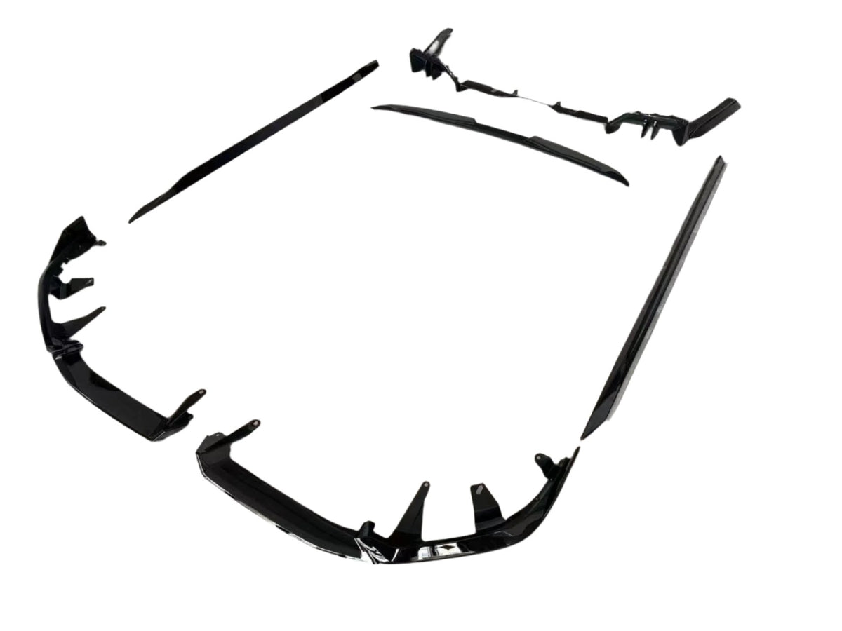 Black car body kit components are arranged on a plain white background. The pieces include bumpers and side skirts, designed to enhance vehicle aerodynamics and appearance.