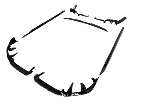 Black car body kit components are arranged on a plain white background. The pieces include bumpers and side skirts, designed to enhance vehicle aerodynamics and appearance.