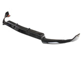 A glossy black car front lip splitter lies on a plain white background, showcasing its curved aerodynamic design and streamlined edges.