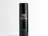 A black aerosol can stands upright on a white surface. It features text reading, 