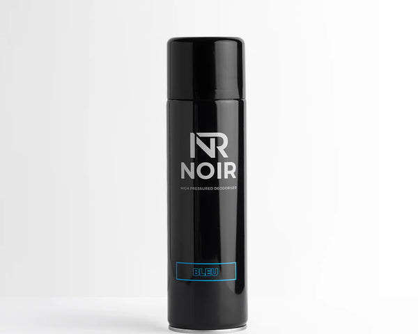 A black aerosol can stands upright on a white surface. It features text reading, "NR NOIR," "High Pressured Deodoriser," and "BLEU" in blue. The background is plain white.