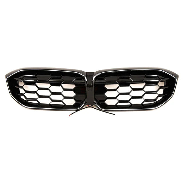 A black car grille with honeycomb design, featuring two separate sections joined in the center. Wires protrude from the middle, suggesting electronic integration. The background is plain white.