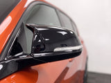 Close-up of a gloss black M-style wing mirror cover on a BMW 1 Series F20 | Carbon Accents