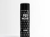 A black aerosol can stands on a smooth surface with a minimalist background. The can displays the text: 