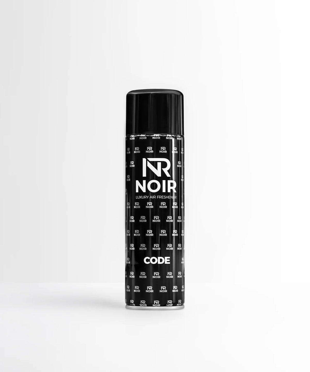 A black cylindrical can labeled "NR NOIR LUXURY AIR FRESHENER CODE" stands upright. It features a repeating logo pattern in a minimalist white room.