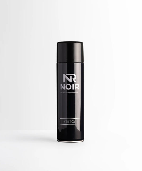 A black cylindrical deodorant can labeled "NR NOIR HIGH PRESSURED DEODORISER CREDO" stands upright, centered on a smooth white surface against a light gray background.