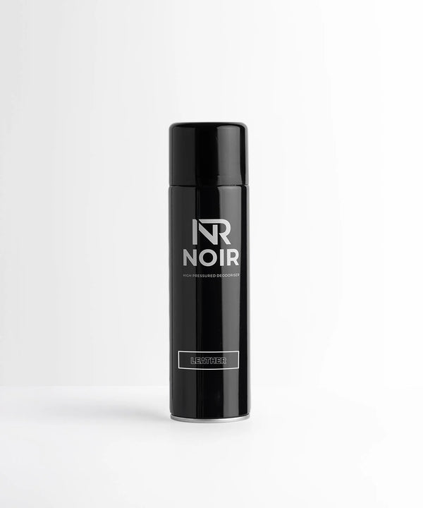 A black can labeled "NR NOIR" with "HIGH PRESSURED DEODORISER" and "LEATHER." It stands on a plain white surface against a light gray background, conveying a minimalist aesthetic.