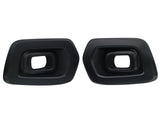 Two black exhaust tips with rectangular openings are facing forward. They are placed side by side against a plain white background.