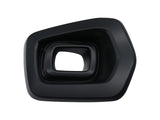 A black, geometrically shaped plastic object with layered, beveled edges, sits isolated against a plain white background. The object has a central rectangular opening.