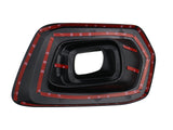 A black, rectangular car part with a hollow center is lined with red adhesive strips, featuring repeated 