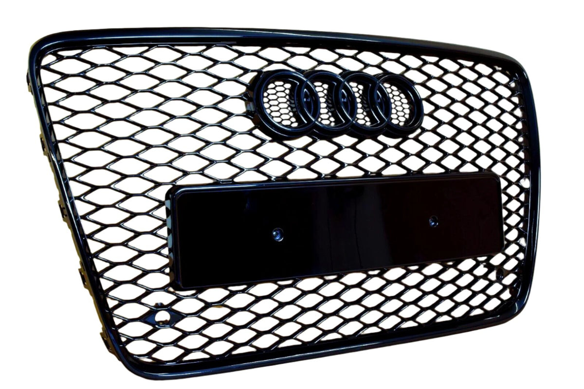A black, honeycomb-patterned car grille featuring four linked rings at the top, with a rectangular placeholder for a license plate, set against a white background.