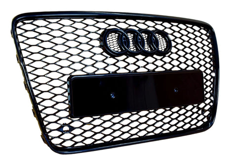 A black, honeycomb-patterned car grille featuring four linked rings at the top, with a rectangular placeholder for a license plate, set against a white background.
